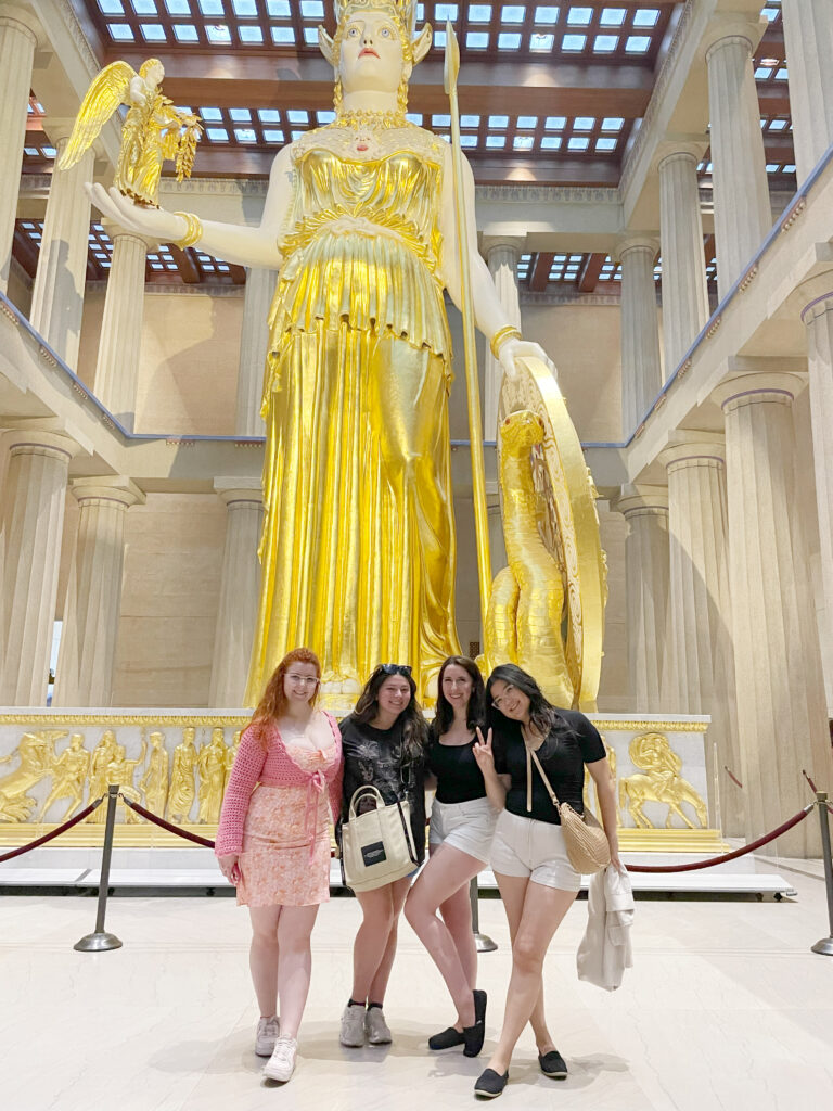 4 friends smiling in front of the pantheon in nashville