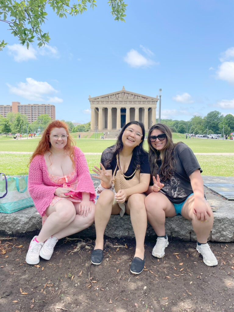 3 friends smiling in front of the pantheon in nashville