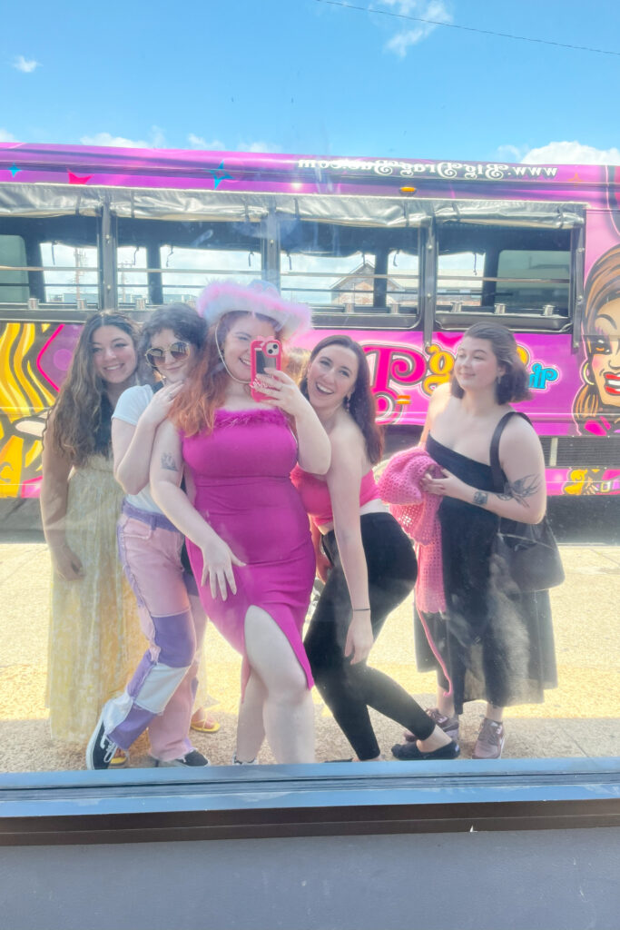group of friends, bachelorette, smiling in front of suzy wong's drag party bus in nashville