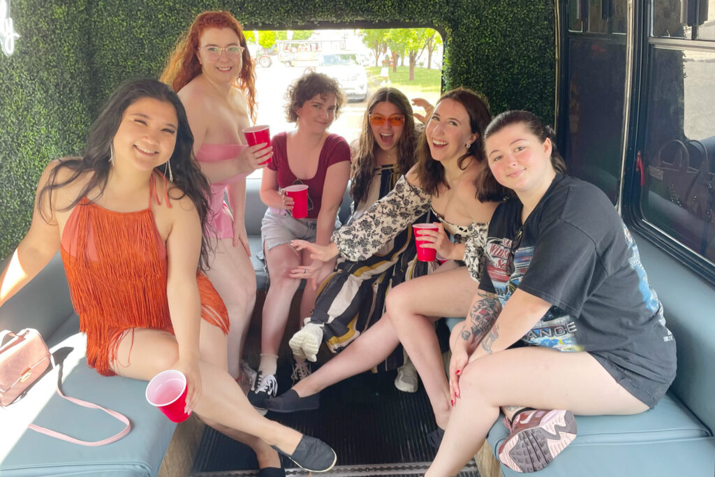 a group of 6 friends smiling at the camera while on a party bus in nashville