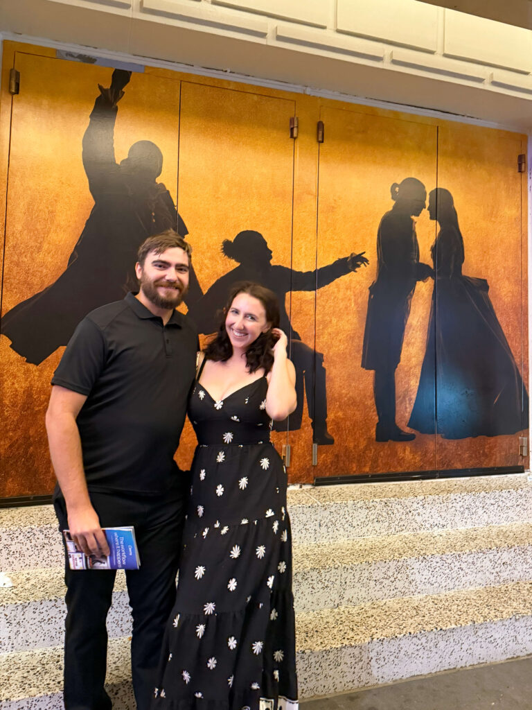man and wife posing at hamilton on broadway